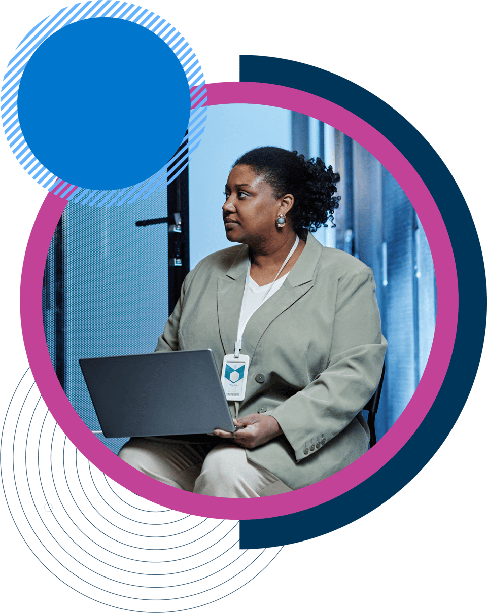 Woman wearing lanyard using laptop in glass building