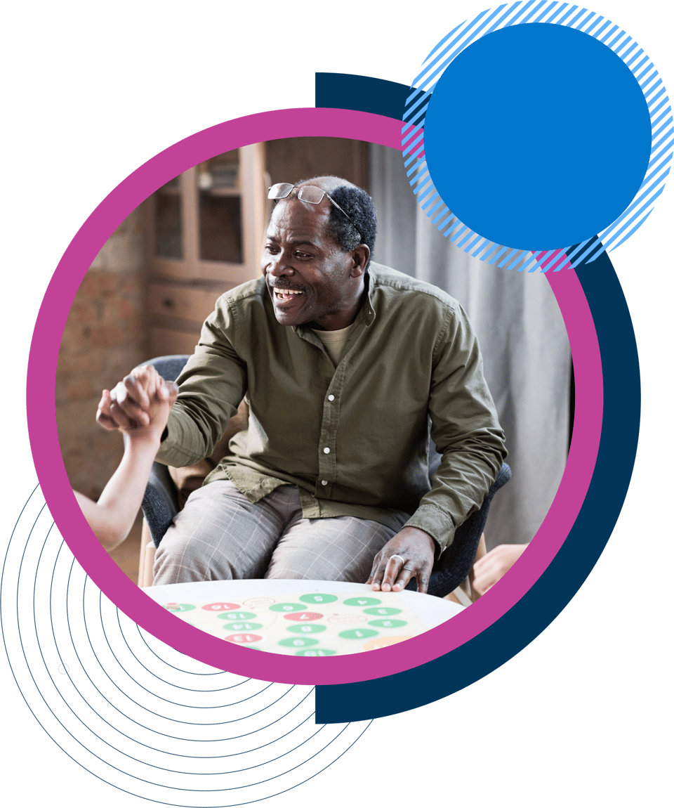 smiling man sat down in chair in care home