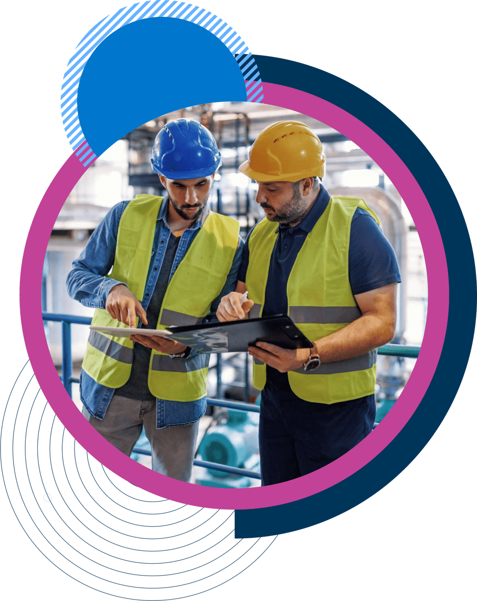 Two colleagues in hard hats in a workshop