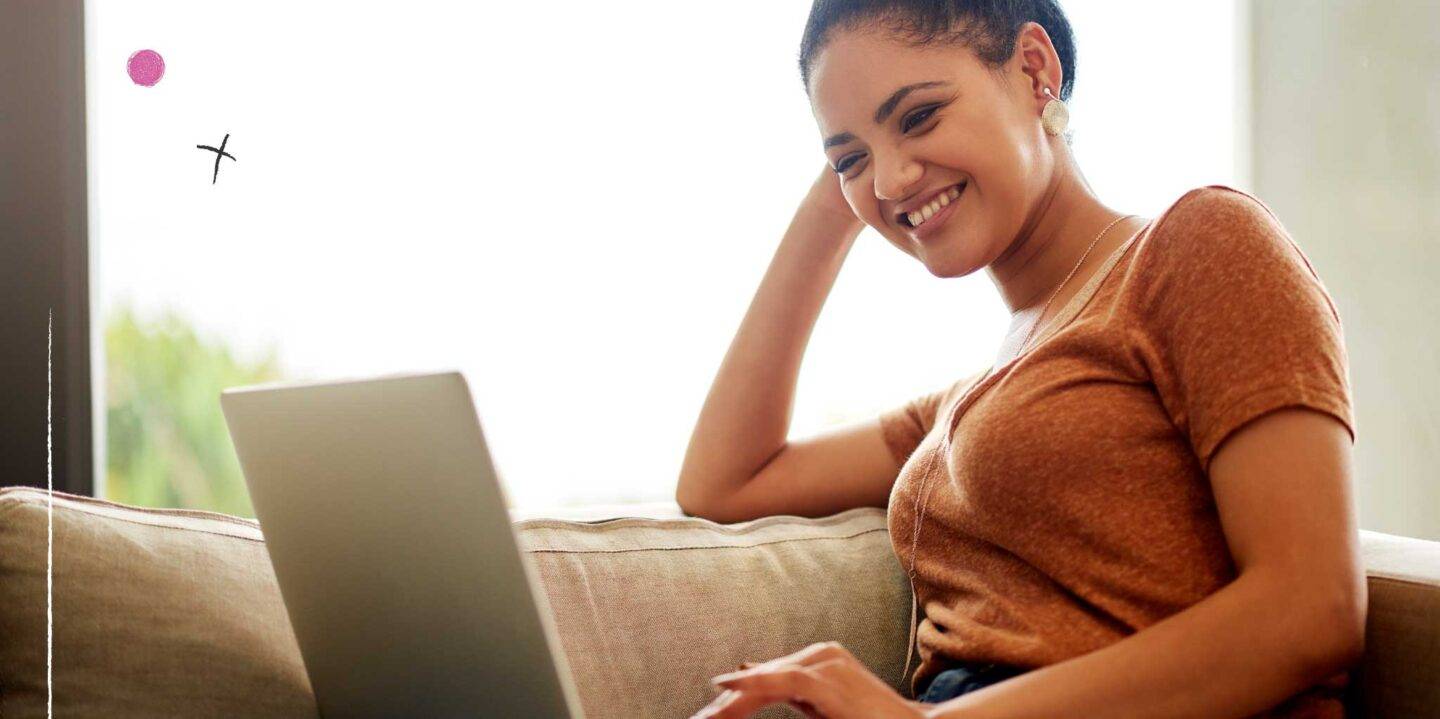 Lady sitting on sofa looking at laptop