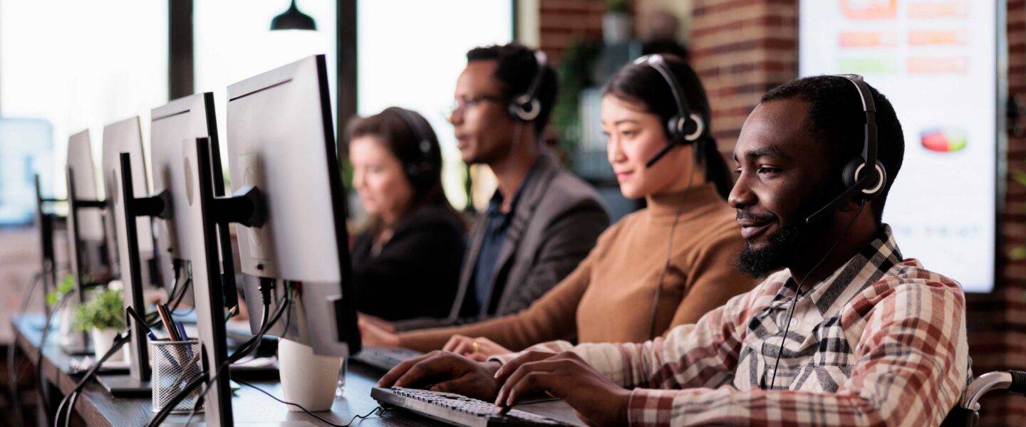 people at computers wearing headsets